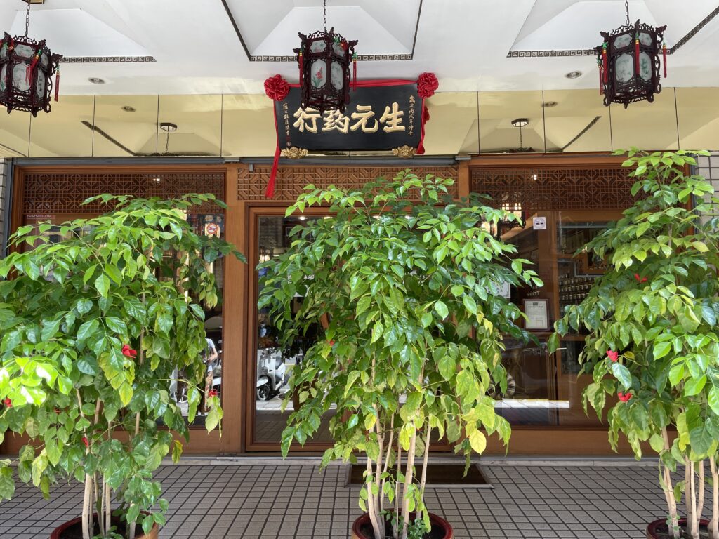 「生元藥行」の看板と店先に置かれた観葉植物