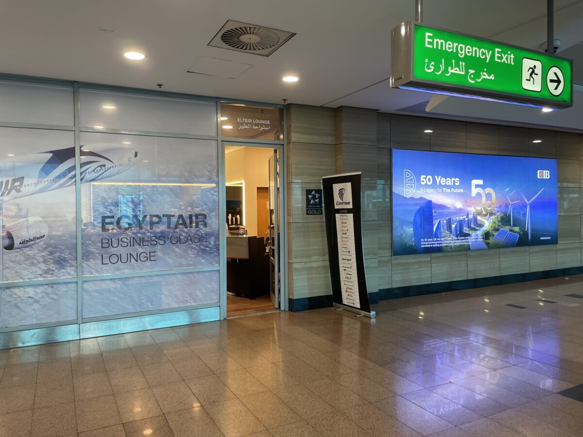 EGYPTAIR LOUNGEと記したガラス張りの入口。通路の天井に非常口の緑の案内が下がる