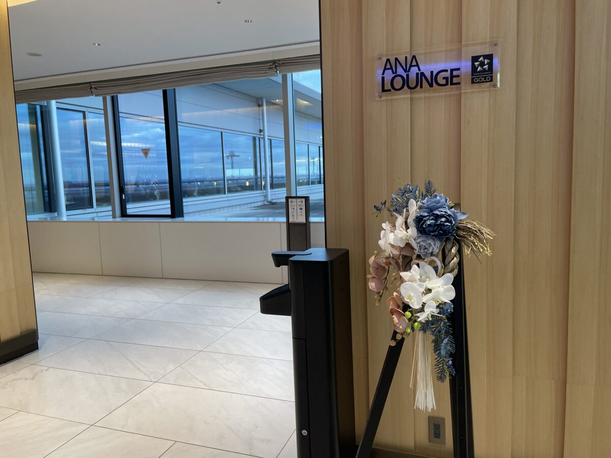 ANA LOUNGEと掲げた入口の自動改札。脇に大きな花が生けられ、奥は一面のガラス窓になっている